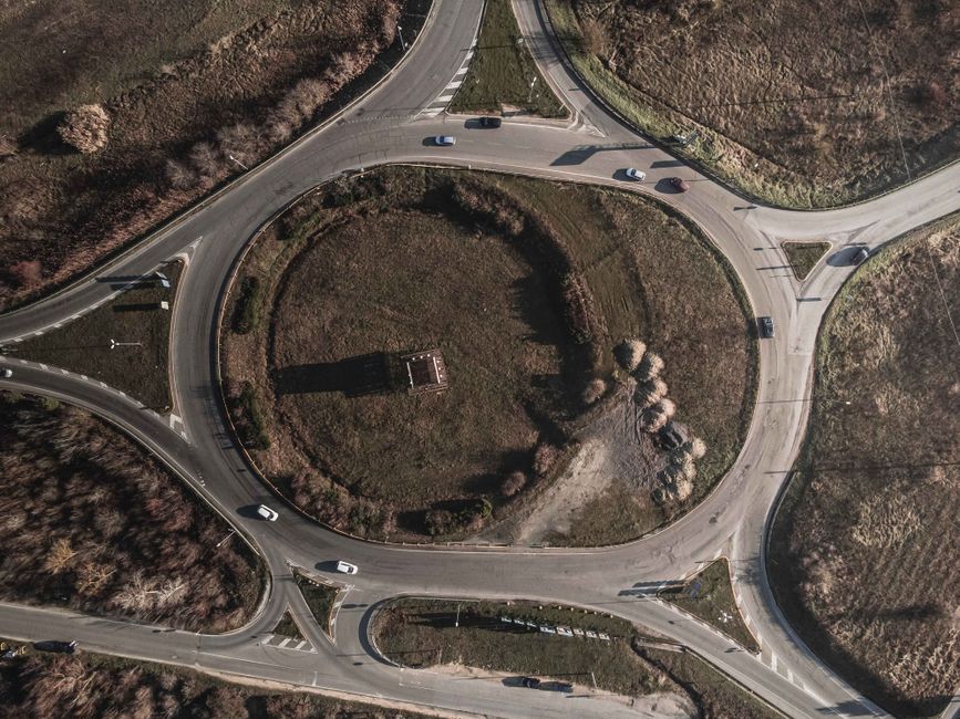 Aerial photograph of a circular traffic roundabout in rural landscape.